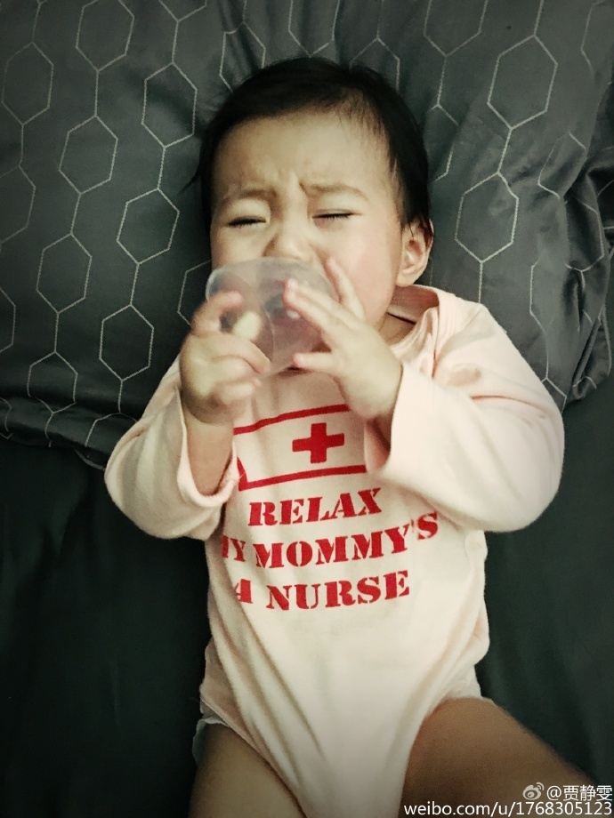 贾静雯在微博上晒出女儿大眼萌照，自曝女儿咘咘长牙发烧要抱抱，老公修杰楷半边肩膀实力出镜，一家人十分幸福。