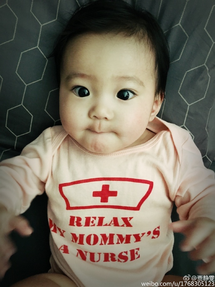 贾静雯在微博上晒出女儿大眼萌照，自曝女儿咘咘长牙发烧要抱抱，老公修杰楷半边肩膀实力出镜，一家人十分幸福。