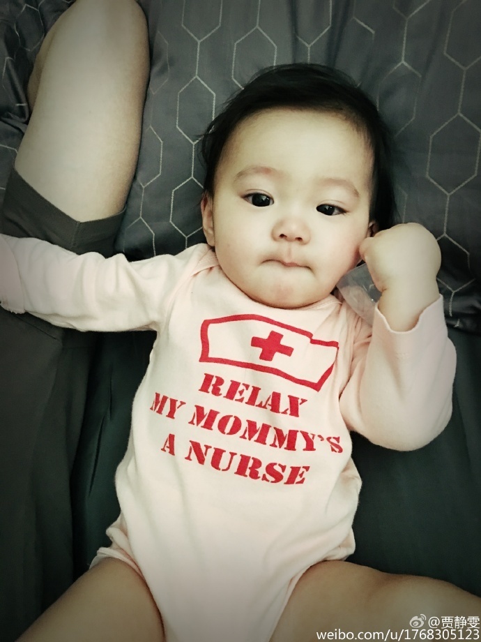 贾静雯在微博上晒出女儿大眼萌照，自曝女儿咘咘长牙发烧要抱抱，老公修杰楷半边肩膀实力出镜，一家人十分幸福。